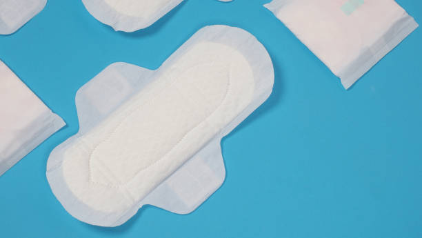Woman sanitary napkins on blue background. Top view. Absorbent pads worn by women to absorb menstrual blood. Comfortable white sanitary napkins arranged on light blue paper. Represent Hygiene concept toallas sanitarias de mujer sobre fondo azul. vista superior. almohadillas absorbentes que usan las mujeres para absorber la sangre menstrual. cómodas toallas sanitarias blancas dispuestas sobre papel azul claro. representar el concepto de higiene