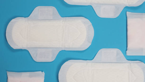 Woman sanitary napkins on blue background. Top view. Absorbent pads worn by women to absorb menstrual blood. Comfortable white sanitary napkins arranged on light blue paper. Represent Hygiene concept toallas sanitarias de mujer sobre fondo azul. vista superior. almohadillas absorbentes que usan las mujeres para absorber la sangre menstrual. cómodas toallas sanitarias blancas dispuestas sobre papel azul claro. representar el concepto de higiene