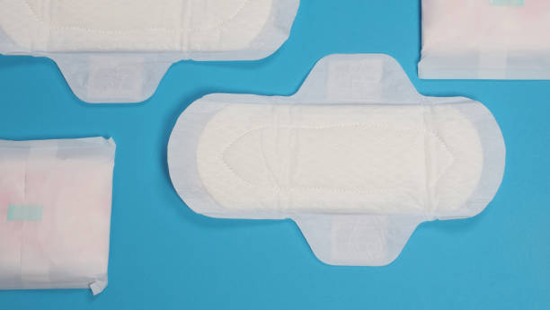 Woman sanitary napkins on blue background. Top view. Absorbent pads worn by women to absorb menstrual blood. Comfortable white sanitary napkins arranged on light blue paper. Represent Hygiene concept toallas sanitarias de mujer sobre fondo azul. vista superior. almohadillas absorbentes que usan las mujeres para absorber la sangre menstrual. cómodas toallas sanitarias blancas dispuestas sobre papel azul claro. representar el concepto de higiene