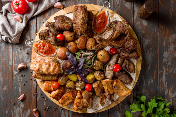 istock platter of different kebabs on board, chicken kekbab, lula kebab, lamb kebab, beef kebab, fried potatoes and mushrooms top view on wooden table 1388982638