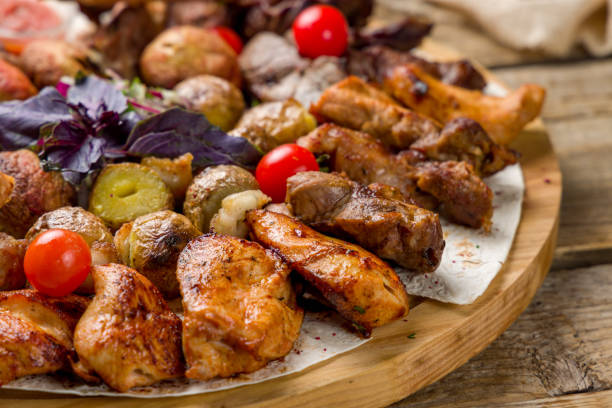 istock platter of different kebabs on board, chicken kekbab, lula kebab, lamb kebab, beef kebab, fried potatoes and mushrooms macro close up 1388982648