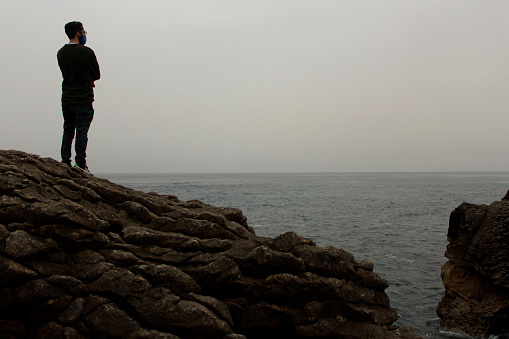 A man looks on in a cloudy day in the fisherman village of San Vicente de la Barquera in the northern region of Cantabria, Spain. He seems to seek in the Cantabrian Sea the answers to his troubles.