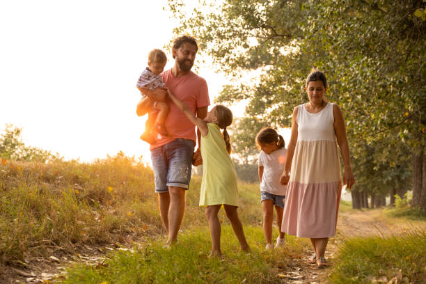 istock Parents with three children enjoy walk in the meadow during spring day 1388989949