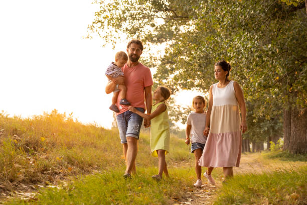istock Caring parents with three children enjoy walk in the meadow during spring day 1388989950