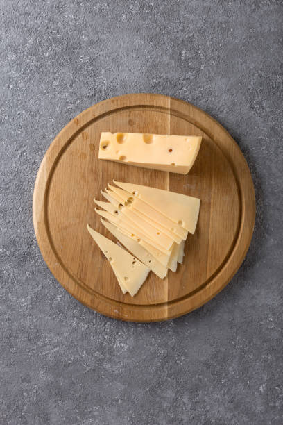 istock Piece of cheese and slices on a kitchen board close up 1388990889