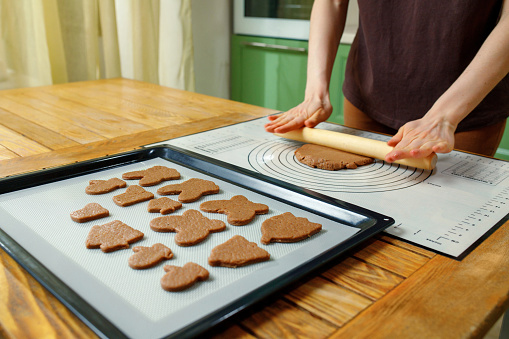 A woman cooking holiday homemade cookies on a silicone baking mat.