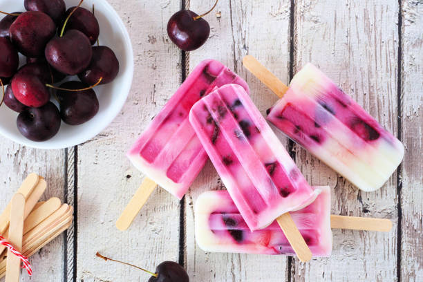 istock Healthy cherry yogurt popsicles table scene over rustic white wood 1388991602