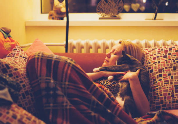 istock Woman and her cat resting together on sofa 1388993089