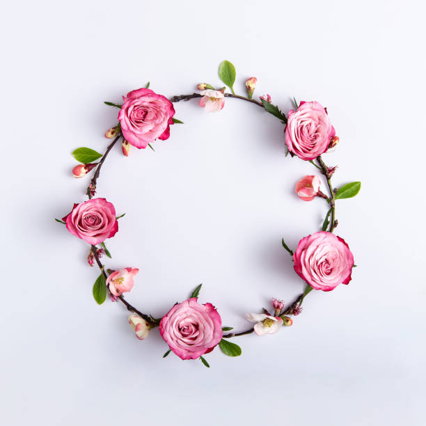 istock Round frame made of red roses on a light gray background. 1388994016
