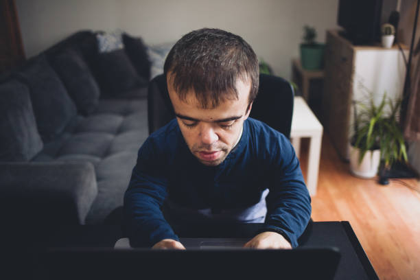 istock Young man with dwarfism working from home 1388994045