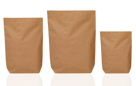 Three different sized brown paper bags on white background