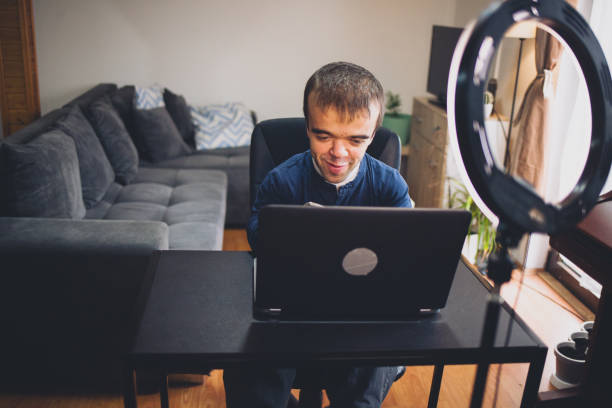 istock Young man with dwarfism working from home 1388996381