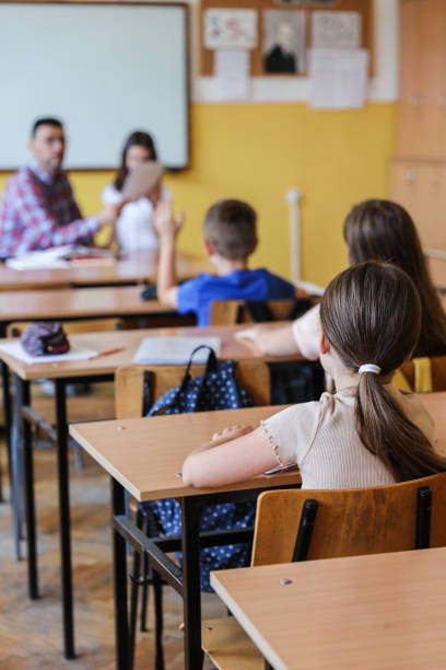 istock School children sitting at desks in classroom 1388997601