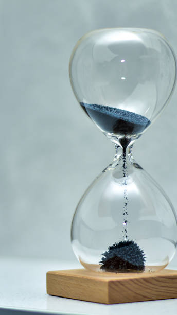 istock Flowing hourglass on wooden base 1388997948