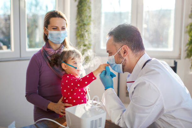 Pediatrician applying medicine inhalation treatment on a little baby girl Pediatrician applying medicine inhalation treatment on a little baby girl pediatric nebulizer mask stock pictures, royalty-free photos & images