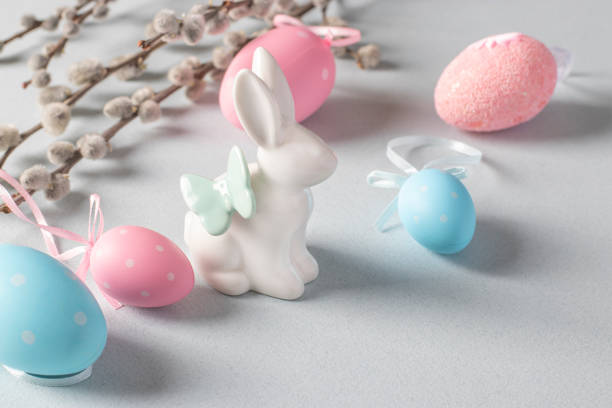 istock Easter bunny, pussy willow, pink and blue eggs on pastel background. Easter concept 1389001917