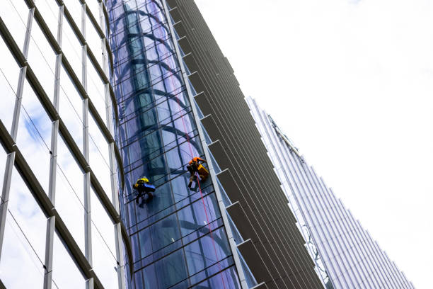 istock Window cleaners working on highrise office building, white background with copy space 1389009192