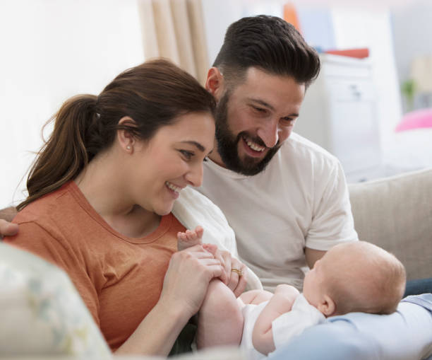 Young family having fun with their new born baby stock photo