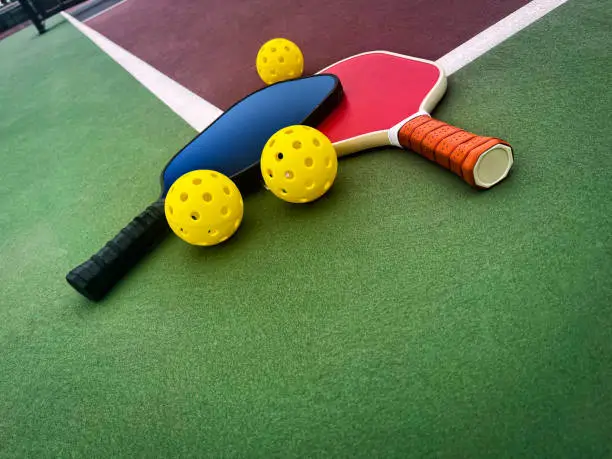 Photo of Pickleball Paddles and Balls on a court