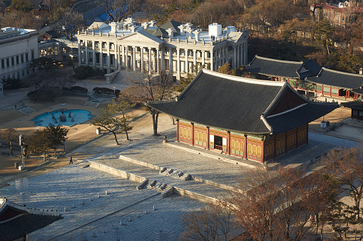 Aerial panorama over the entrance to Gyeongbokgung Palace overlooked by mountains in the heart of Seoul, South Korea’s vibrant capital city.