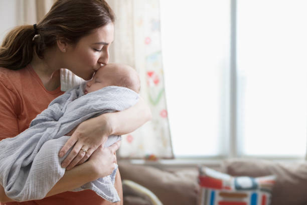 мама с новорожденным ребенком дома - mother baby new kissing стоковые фото и изображения