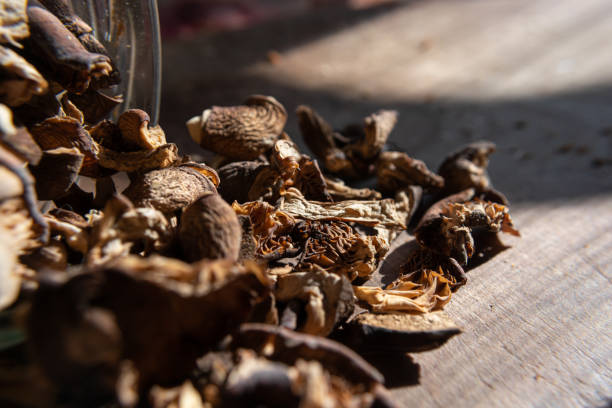 istock Dried mushrooms scattered with jars on a wooden table. 1389015537