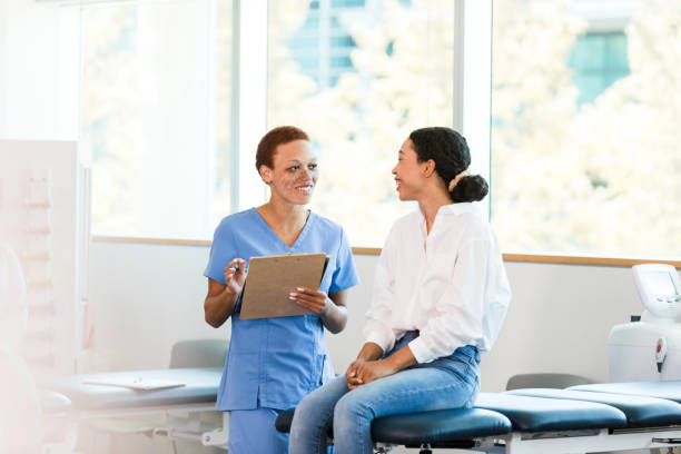 istock Occupational therapist smiles while reviewing records with female patient 1389017435