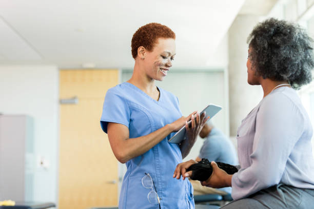 istock Smiling female therapist uses digital tablet while listening to patient 1389017454