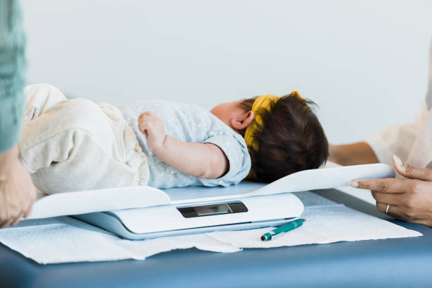 istock Baby lays on a weight scale 1389017554