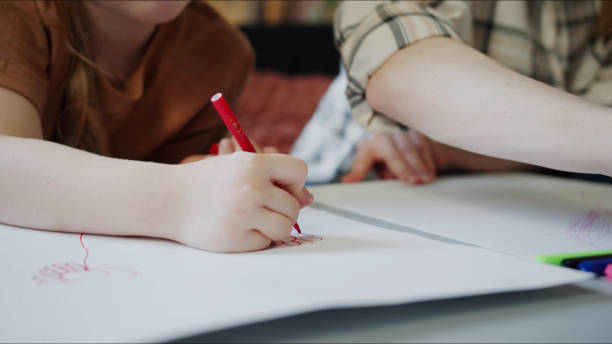 istock Child visiting aunt. They draw with pencils together 1389018762