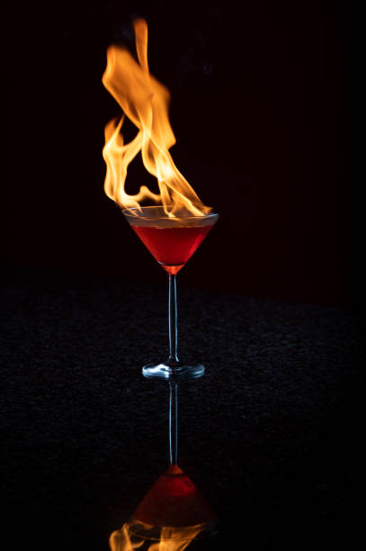 brennender flammender martini-cocktail kosmopolitisch - martini brand vermouth stock-fotos und bilder