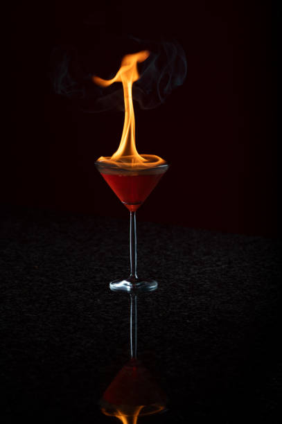 brennender flammender martini-cocktail kosmopolitisch - martini brand vermouth stock-fotos und bilder
