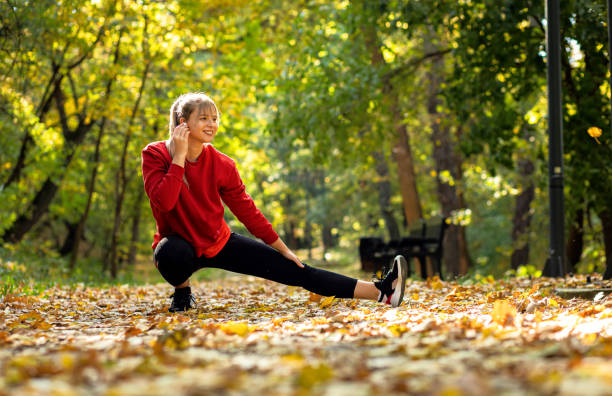 istock Young woman warming up and stretching before running in park. 1389022101