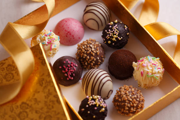 Chocolate Bonbons in Golden Box Handmade chocolate bonbons in golden gift box and ribbon. chocolate truffle stock pictures, royalty-free photos & images