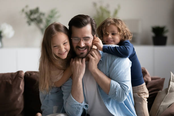 istock Close up happy father with kids having fun on couch 1389029738
