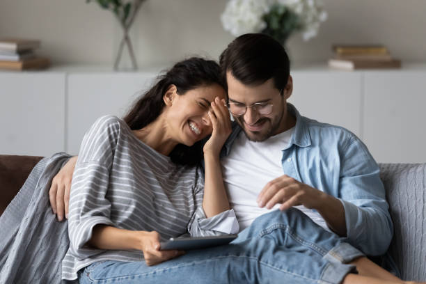 istock Happy man and laughing woman hugging, using tablet together 1389029780