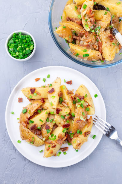 istock Bacon and onion potato salad dressed with apple cider vinegar and mustard, on plate, vertical, top 1389031971