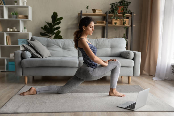 istock Healthy woman train online with computer at home 1389032725