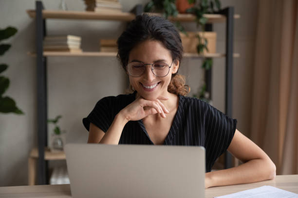 istock Smiling Hispanic woman work online on laptop 1389032734