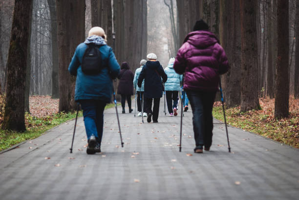 노인을 위한 폴 워킹, 여성 그룹이 공원에서 건강을 위해 걷고 있습니다. - nordic walking walking relaxation exercise women 뉴스 사진 이미지