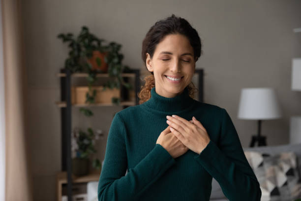 istock Happy Latin woman hold hands on heart feeling grateful 1389033529
