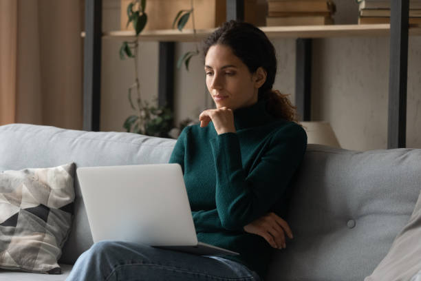istock Pensive young Latin woman work on laptop thinking 1389033570