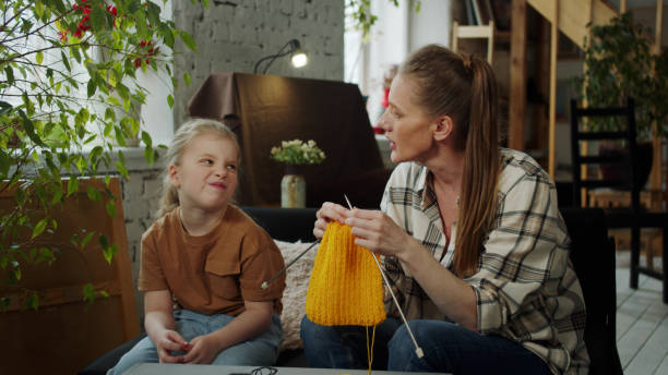 istock Mom chats with her daughter while knitting 1389033579