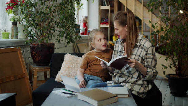 istock A woman does homework with her daughter. She reads her a task from a textbook 1389037876