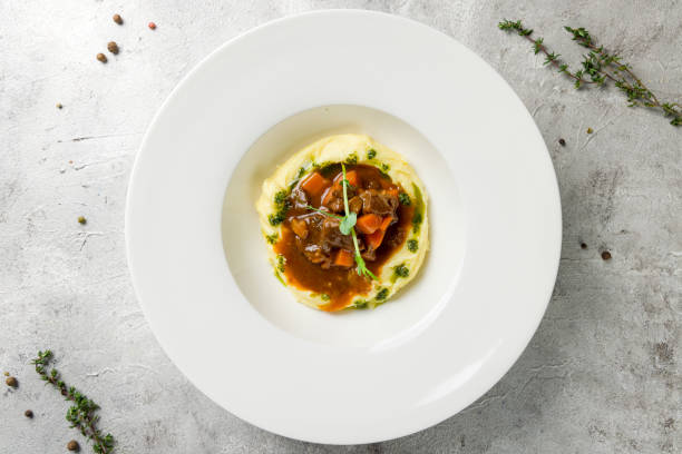 istock Beef cheeks with mashed potatoes and sauce demiglass on concrete table top view 1389039138