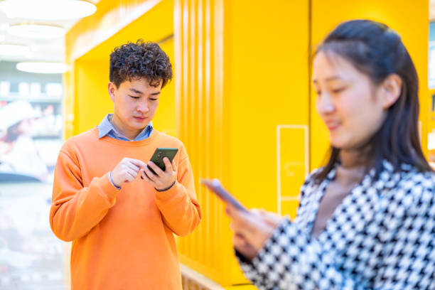 istock Asian young people using smartphone in shopping mall 1389051755