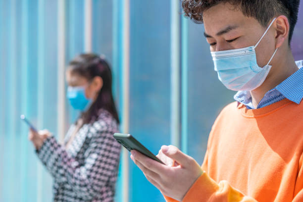 istock Asian young people using smartphone in city street 1389051960
