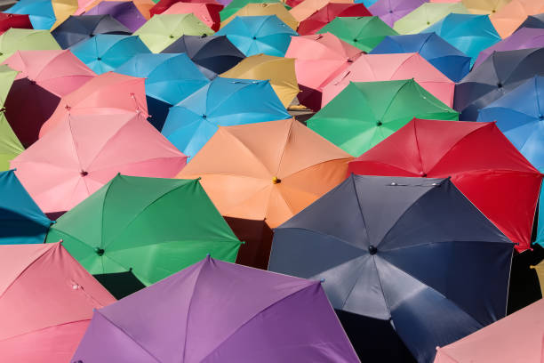 Many colorful multicolor open umbrella on floor outdoor background