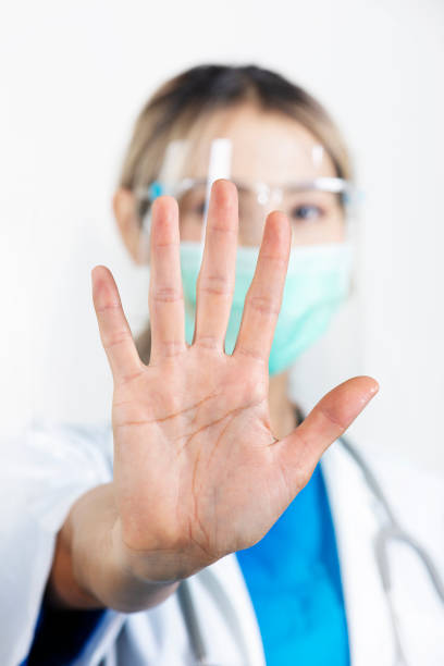 istock Female doctor showing stop gesture with outstretched hands. 1389057374