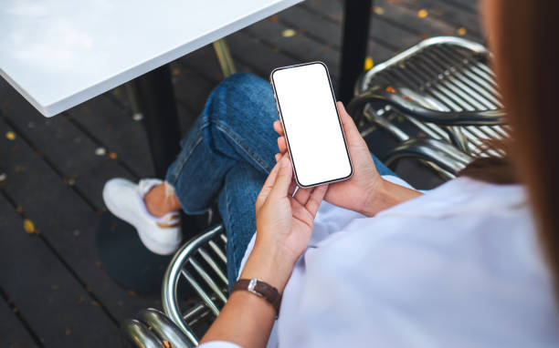 istock Mockup image of a woman holding and using mobile phone with blank desktop screen 1389062066